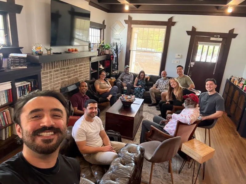Moby taking a selfie with a group in a lounge
