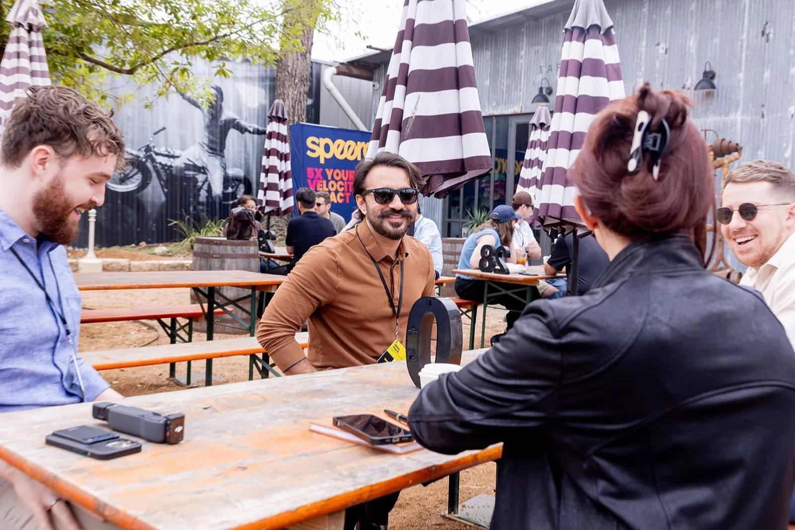 Moby talking with marketers at an outdoor table at a Speero event